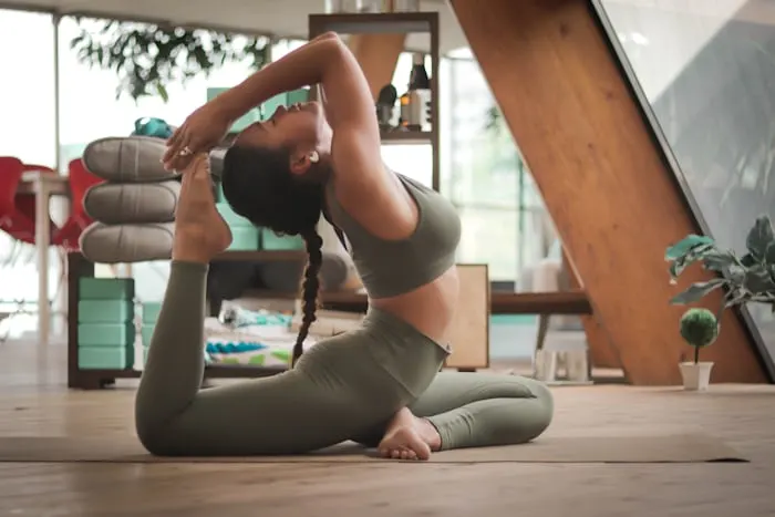 A woman holding a yoga pose in a bright studio