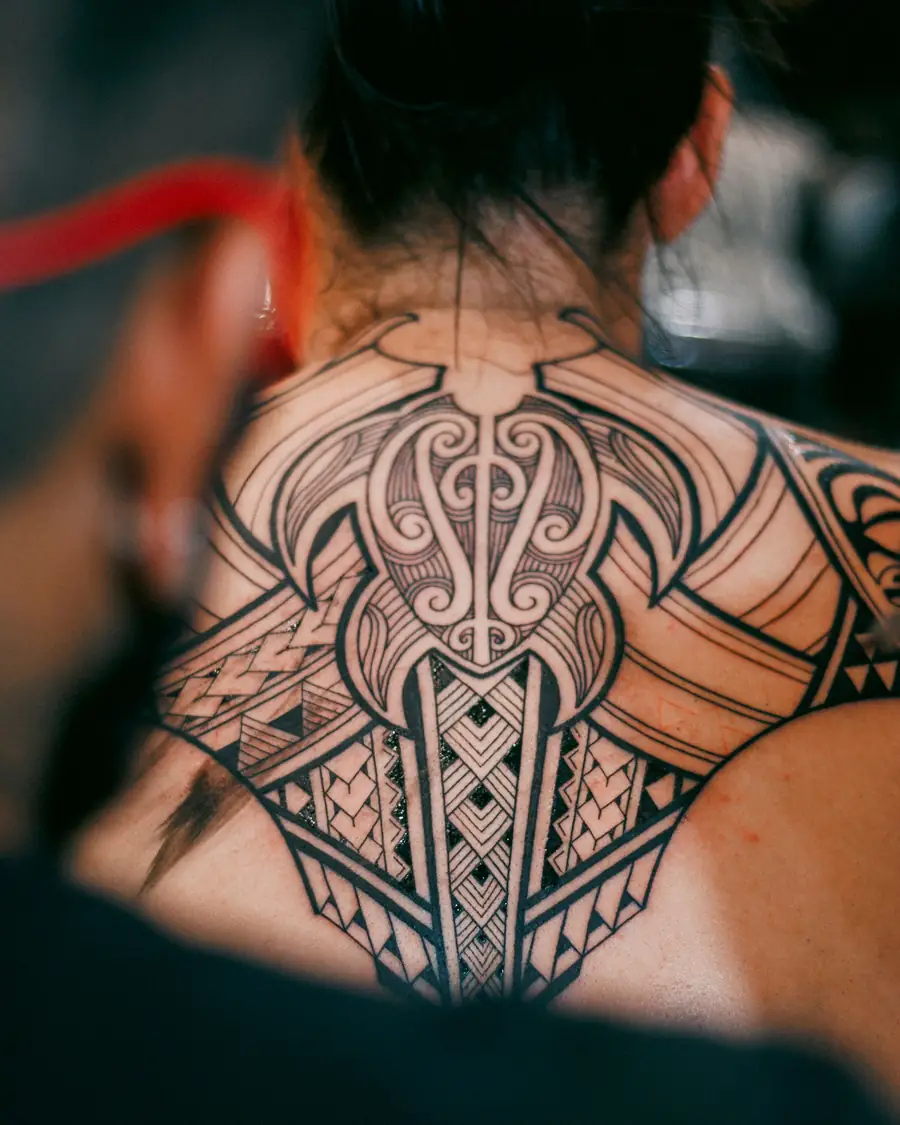 Symmetrical tribal-inspired blackwork across the upper back